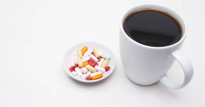 cup-of-coffee-and-saucer-of-pills-on-white-background-close-up